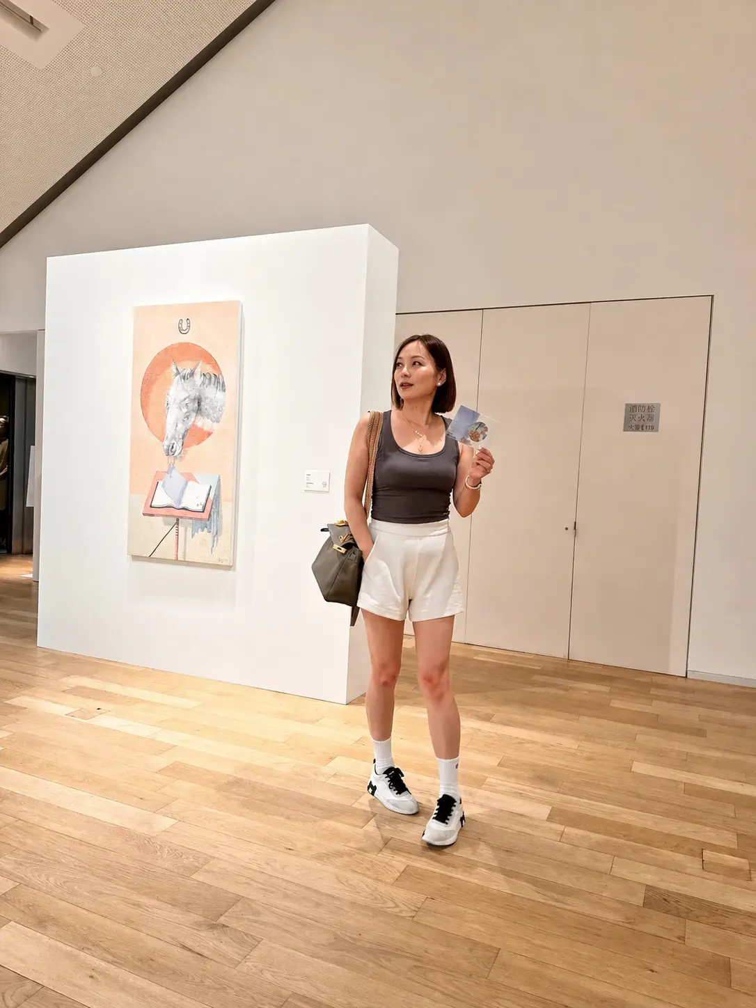 Alicia Dai 站在艺术展览作品旁
